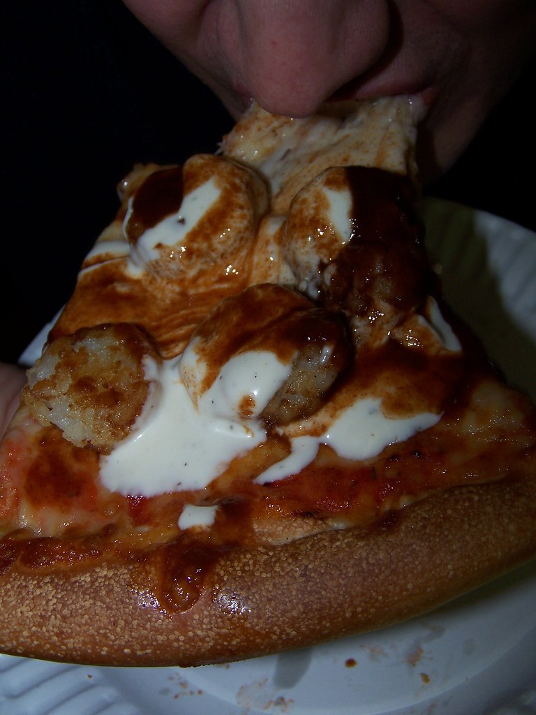 Tom chows on tator-tot pizza with ranch dressing and chipotle chile Tabasco sauce.